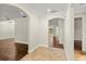 Hallway with hardwood floors, travertine tile, and an arched entryway to other rooms of the home at 6185 Shoreline Dr, Port Orange, FL 32127