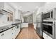 Modern kitchen with stainless steel appliances, white cabinetry, and gleaming hardwood floors, offering style and functionality at 6185 Shoreline Dr, Port Orange, FL 32127