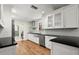 A kitchen with white cabinets, stainless steel appliances, a large sink, and hardwood flooring at 6185 Shoreline Dr, Port Orange, FL 32127