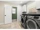 Well-lit laundry room with front-loading washer and dryer and plenty of storage space at 6185 Shoreline Dr, Port Orange, FL 32127