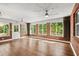 Light-filled sunroom with brick accents, wood floors, and multiple windows at 6185 Shoreline Dr, Port Orange, FL 32127