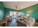 Cozy living room with comfortable seating, a ceiling fan, and sliding glass doors to a private balcony at 719 S Beach St # 302B, Daytona Beach, FL 32114