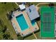 Aerial view of a community pool, with a tennis court and lounge chairs at 719 S Beach St # 302B, Daytona Beach, FL 32114