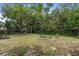 Spacious backyard featuring mature trees, a garden, and a swing set at 736 Lindenwood W Cir, Ormond Beach, FL 32174