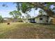Expansive backyard with mature trees, a playset, and plenty of space for activities at 736 Lindenwood W Cir, Ormond Beach, FL 32174