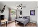 Comfortable bedroom with ceiling fan, wood floors, and large window allowing lots of natural light at 736 Lindenwood W Cir, Ormond Beach, FL 32174