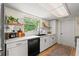 Bright kitchen features white cabinets, modern appliances, and a window overlooking a lush, green outdoor area at 736 Lindenwood W Cir, Ormond Beach, FL 32174