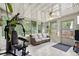 Enclosed sunroom with ceiling fan, tile flooring, and a full home gym setup overlooking a lovely yard at 736 Lindenwood W Cir, Ormond Beach, FL 32174