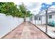 Inviting backyard with white vinyl fence, brick-paved walkway, and deck area with canopy at 952 Northbrook Dr, Ormond Beach, FL 32174