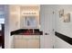 Bathroom featuring decorative mirror and lights, a door and vanity with a red sink at 952 Northbrook Dr, Ormond Beach, FL 32174