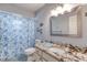 Well-lit bathroom with a granite countertop vanity and a shower with a blue and white floral shower curtain at 952 Northbrook Dr, Ormond Beach, FL 32174