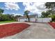 Long concrete driveway with large garage leading to backyard privacy gate at 952 Northbrook Dr, Ormond Beach, FL 32174