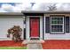 Close-up of the home's entry, showcasing the red door and black shutters at 952 Northbrook Dr, Ormond Beach, FL 32174