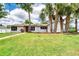 Charming single-story home with a well-manicured lawn and mature palm trees enhancing its curb appeal at 952 Northbrook Dr, Ormond Beach, FL 32174
