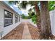 Side yard featuring brick walkway, white privacy fence, and mature shade trees at 952 Northbrook Dr, Ormond Beach, FL 32174