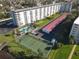 An aerial view of a condo complex featuring a tennis court, pool, covered parking, and balconies at 100 Silver Beach Ave # 608, Daytona Beach, FL 32118