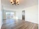 Spacious living room with laminate flooring, a chandelier, and sliding glass doors to the patio at 100 Silver Beach Ave # 608, Daytona Beach, FL 32118