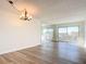 Bright living room with laminate flooring, a chandelier, mirror, and sliding glass doors to the patio at 100 Silver Beach Ave # 608, Daytona Beach, FL 32118
