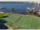 Aerial view of a green tennis court by the water with a bridge in the background at 100 Silver Beach Ave # 608, Daytona Beach, FL 32118