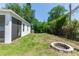 Spacious backyard with green grass, privacy fence, and a brick fire pit at 1005 Flagler Ave, Edgewater, FL 32132