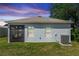 Exterior view of the backyard features a screened porch, two windows, and an AC unit at 1005 Flagler Ave, Edgewater, FL 32132