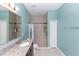 Bright bathroom featuring single sink, large mirror, and walk-in shower at 1005 Flagler Ave, Edgewater, FL 32132