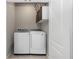 Modern laundry room features a front loading washer and dryer, with storage cabinets above at 1005 Flagler Ave, Edgewater, FL 32132