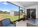 Comfortable screened porch with wicker furniture, overlooking the fenced backyard and shed at 1005 Flagler Ave, Edgewater, FL 32132