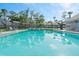 A sparkling community pool reflects the sky, surrounded by lounge chairs and landscaping at 102 Bob White Ct # 102C, Daytona Beach, FL 32119