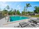 A refreshing community pool with sun loungers, set against a backdrop of lush trees at 102 Bob White Ct # 102C, Daytona Beach, FL 32119