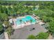 Aerial view of a stunning community pool area surrounded by lush greenery and palm trees at 103 Manor View Ln, Deland, FL 32724