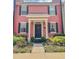 Charming two-story townhome featuring a bright pink facade, black shutters, and manicured landscaping at 103 Manor View Ln, Deland, FL 32724