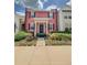 Charming two-story pink townhouse featuring a welcoming front porch and neat landscaping at 103 Manor View Ln, Deland, FL 32724