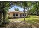 Backyard featuring a light colored house, stepping stones, and mature trees at 1057 Shady Hollow Dr, Deland, FL 32724
