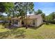The home's backyard features a well-manicured lawn and mature trees, providing privacy and shade at 1057 Shady Hollow Dr, Deland, FL 32724