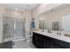 Bathroom features a shower with glass door and double vanity with black cabinetry at 1079 Quaker Ridge Ln, Davenport, FL 33896