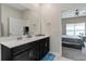 Bathroom featuring a double vanity with black cabinetry and quartz countertops at 1079 Quaker Ridge Ln, Davenport, FL 33896