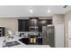 Modern kitchen features black cabinets, stainless appliances, and white quartz countertops at 1079 Quaker Ridge Ln, Davenport, FL 33896