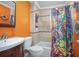 Bright bathroom featuring a vanity, toilet, and a shower with a colorful curtain and tiled wall at 1090 Wakefield Cir, Deltona, FL 32725