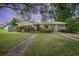 Charming single-story home featuring a lush front yard, covered parking, and mature landscaping at 1090 Wakefield Cir, Deltona, FL 32725