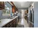 Functional kitchen features stainless steel appliances, dark wood cabinetry, and mosaic tile accents at 1090 Wakefield Cir, Deltona, FL 32725