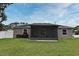 The backyard features a well-maintained lawn, a screened-in patio, and ample space for outdoor activities at 116 Neal Dr, Deltona, FL 32738