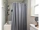 A bathroom with a shower-tub combo, gray-patterned shower curtain, and vanity mirror at 116 Neal Dr, Deltona, FL 32738