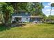 Exterior rear view of the house showcasing an expansive backyard and lawn at 1228 Oakwood Ave, Daytona Beach, FL 32114