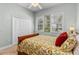 Comfortable bedroom featuring a floral comforter, ceiling fan, and bright windows with plantation shutters at 1309 Wicklow Ln, Ormond Beach, FL 32174