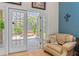 Bedroom sitting area with chair and door to screened patio and hot tub at 1309 Wicklow Ln, Ormond Beach, FL 32174