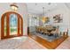 Elegant dining room with a large arched window, a wooden table, and a stylish chandelier, perfect for Gathering gatherings at 1309 Wicklow Ln, Ormond Beach, FL 32174