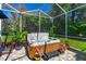 Relaxing hot tub in a screened patio, surrounded by lush greenery and potted plants at 1309 Wicklow Ln, Ormond Beach, FL 32174