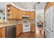 Modern kitchen featuring granite countertops, wooden cabinets, and a view of the dining area at 1309 Wicklow Ln, Ormond Beach, FL 32174