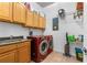 Spacious laundry room with plenty of storage space, washer, dryer, utility sink, and a tile floor at 1309 Wicklow Ln, Ormond Beach, FL 32174